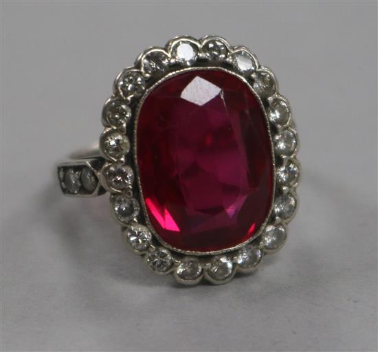 A mid 20th century platinum?, synthetic ruby and diamond set oval dress ring, size I.